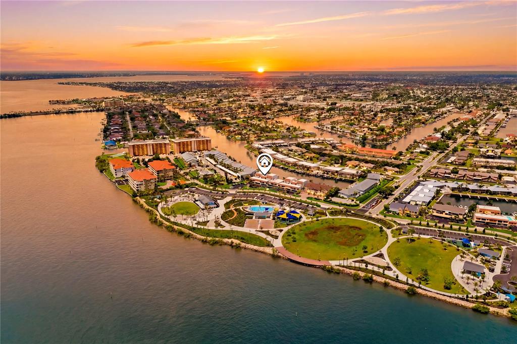 An aerial view of a waterfront residential community at sunset with a location marker — 4218 SE 20TH PLACE UNIT D5, CAPE CORAL, FL