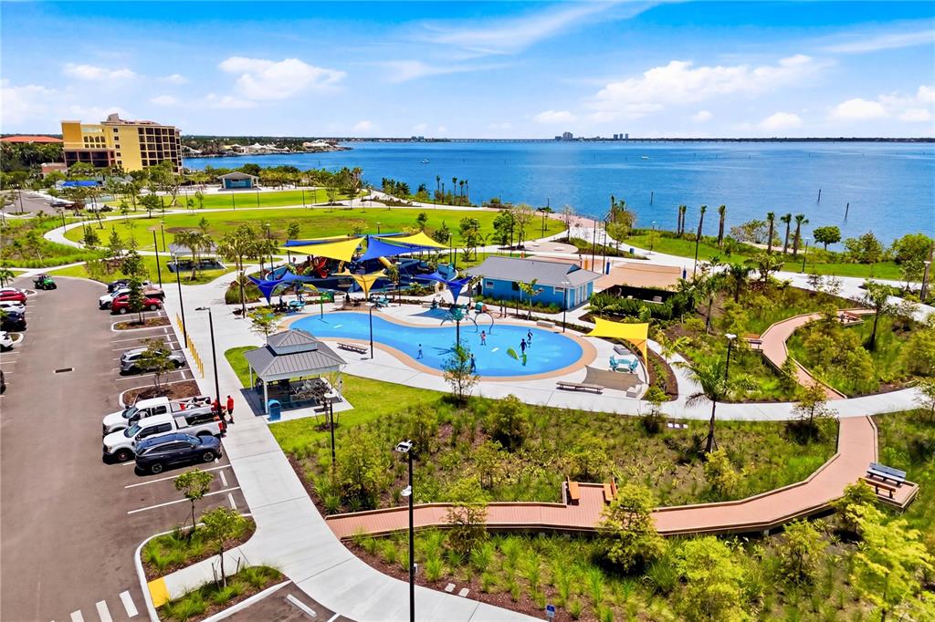 An aerial view shows a waterfront park with a splash pad, playground, and parking lot — 4218 SE 20TH PLACE UNIT D5, CAPE CORAL, FL