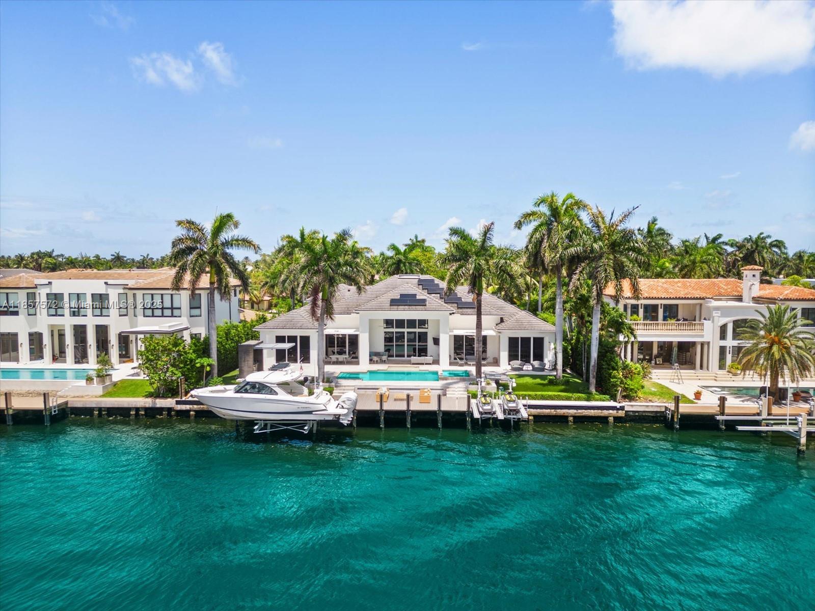 An aerial view of a waterfront house with a pool, boat lift, and palm trees — 224 S ISLAND, Golden Beach FL 33160, GOLDEN BEACH, FL