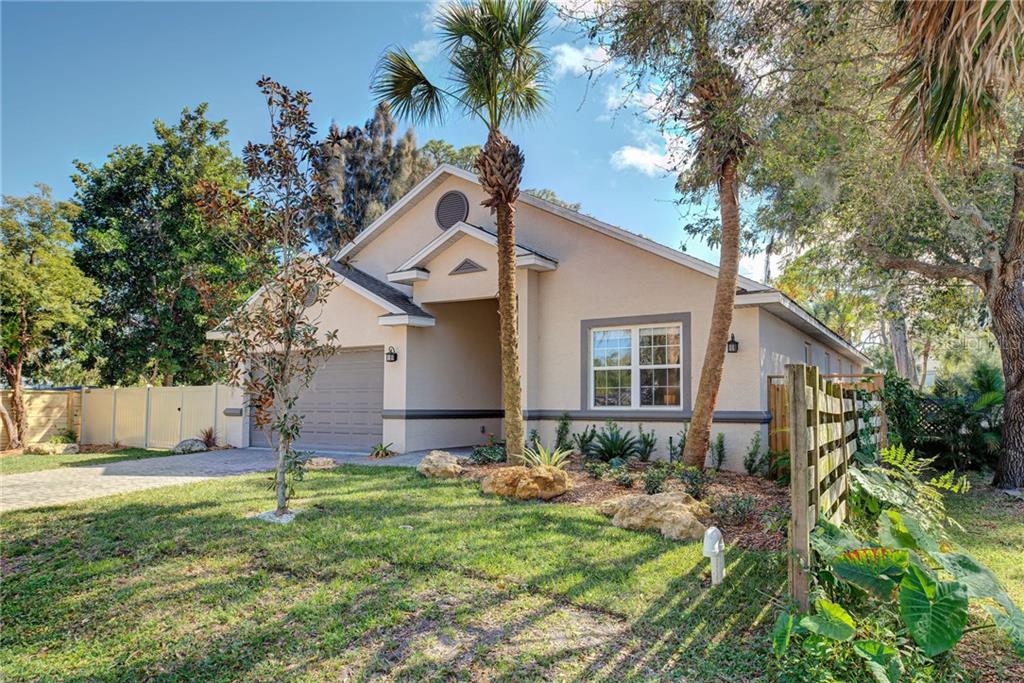 A single-story house with a beige stucco exterior, a two-car garage, and a palm tree — 2330 BRADFORD STREET, SARASOTA, FL