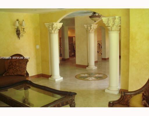 A living room features yellow faux-painted walls, decorative columns, and a glass-topped coffee table — 12425 SW 43rd St, Miami FL 33175, MIAMI, FL