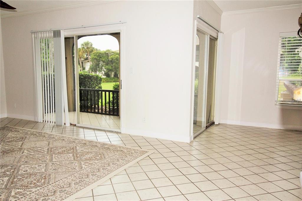 A room with light-colored tile flooring, two sliding glass doors, and a view of greenery — 200 MAITLAND AVENUE UNIT 1, ALTAMONTE SPRINGS, FL