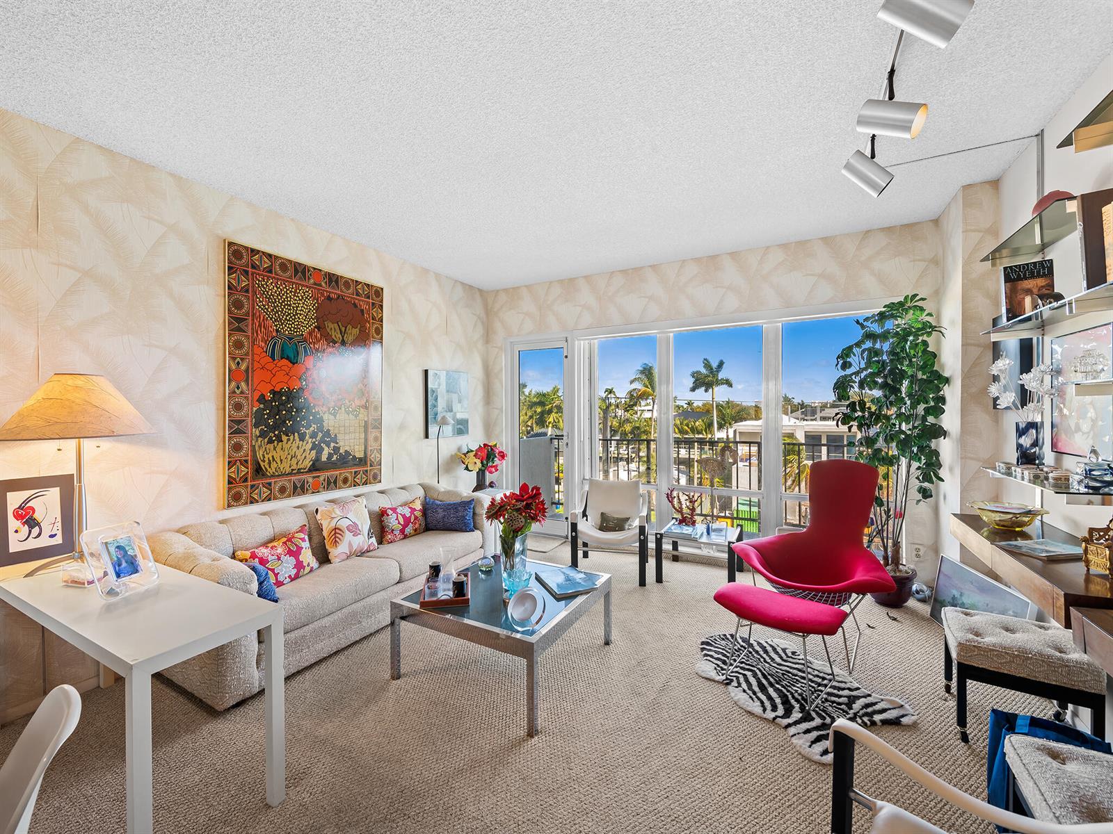 A living room features a beige sofa, a red lounge chair, and a large window — 2500 E Las Olas Boulevard # 404, Fort Lauderdale FL 33301, FORT LAUDERDALE, FL