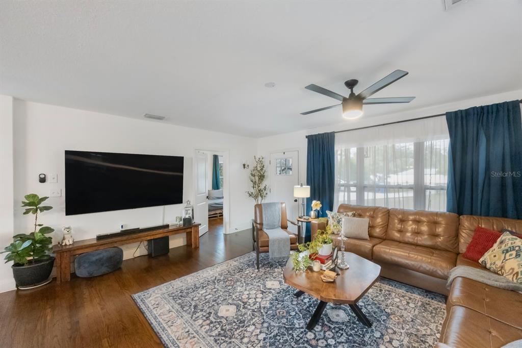 A living room features a leather sectional, a large television, and a patterned area rug — 2504 W FLETCHER AVENUE, TAMPA, FL