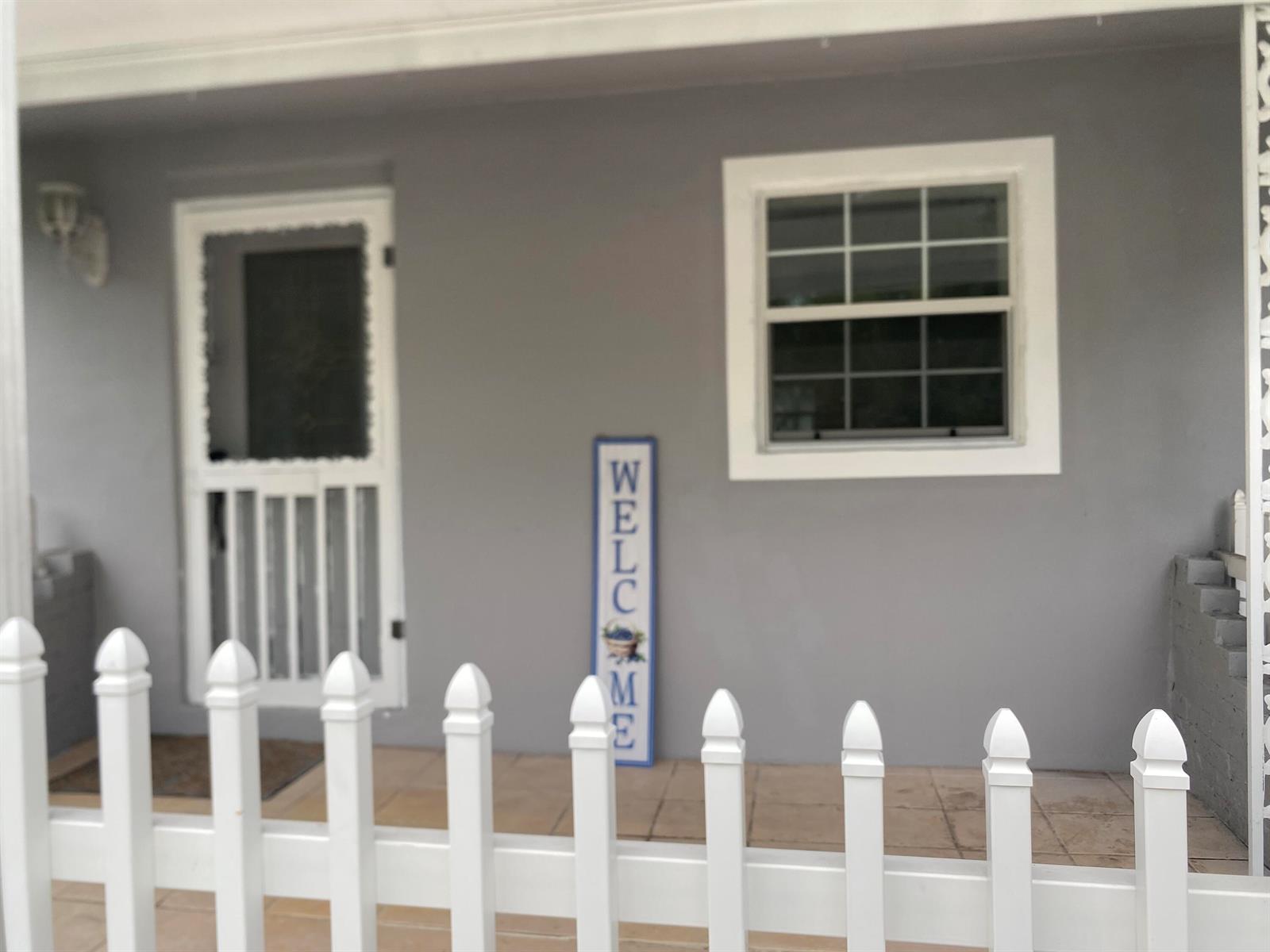 A gray house exterior features a white picket fence, a screen door, and a welcome sign — 1788 SW 8th Street, Okeechobee FL 34974, OKEECHOBEE, FL