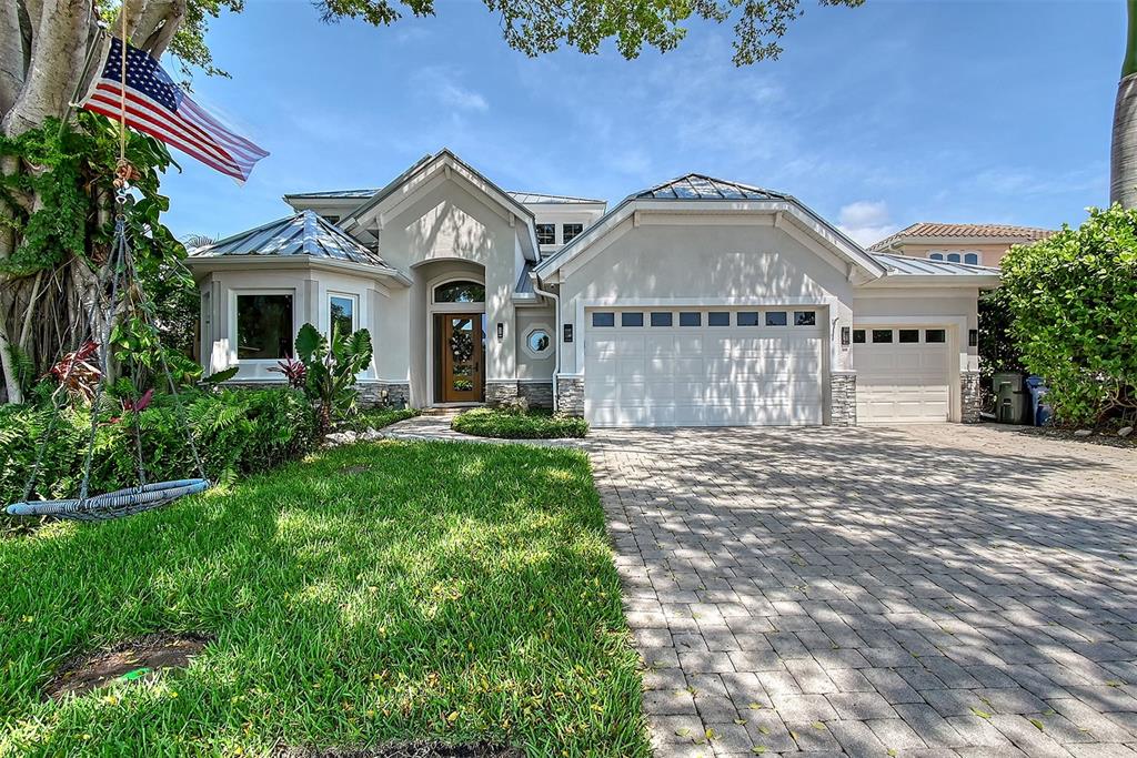 A single-family house with a paved driveway, two garage doors, and a large American flag — 3921 MARAVIC PLACE, SARASOTA, FL