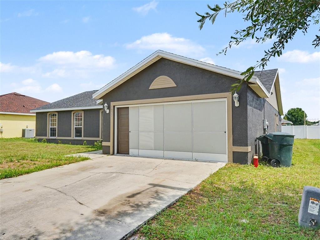 A dark gray house with a white garage screen door and a concrete driveway — 1335 LAUREL GLEN DR, BARTOW, FL