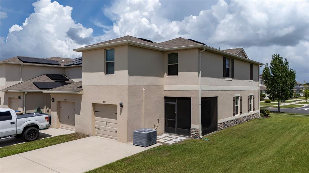 A two-story tan house with dark shutters, a front walkway, and a small tree — 1854 KATZ CROSSING DRIVE, KISSIMMEE, FL