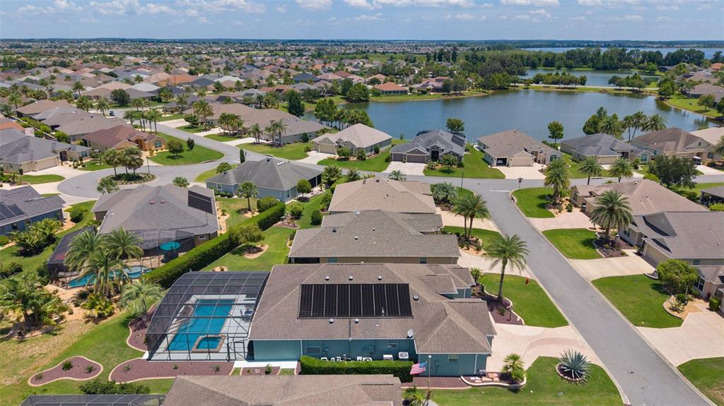 An aerial view of a suburban neighborhood featuring a house with a solar-paneled roof — 1951 GATEHOUSE TERRACE, THE VILLAGES, FL