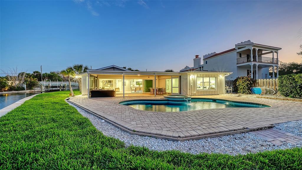 A house with a swimming pool and patio overlooks a canal at sunset — 339 TREASURE BOAT WAY, SARASOTA, FL