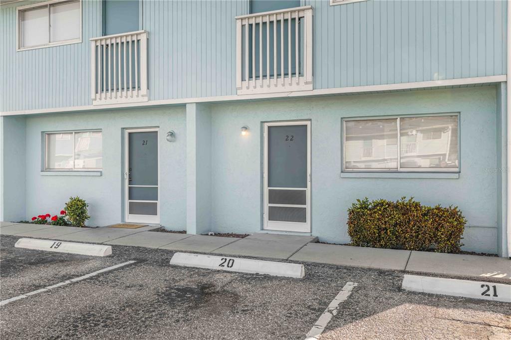 A light blue two-story building exterior features numbered doors and designated parking spaces — 3569 BEE RIDGE, SARASOTA, FL