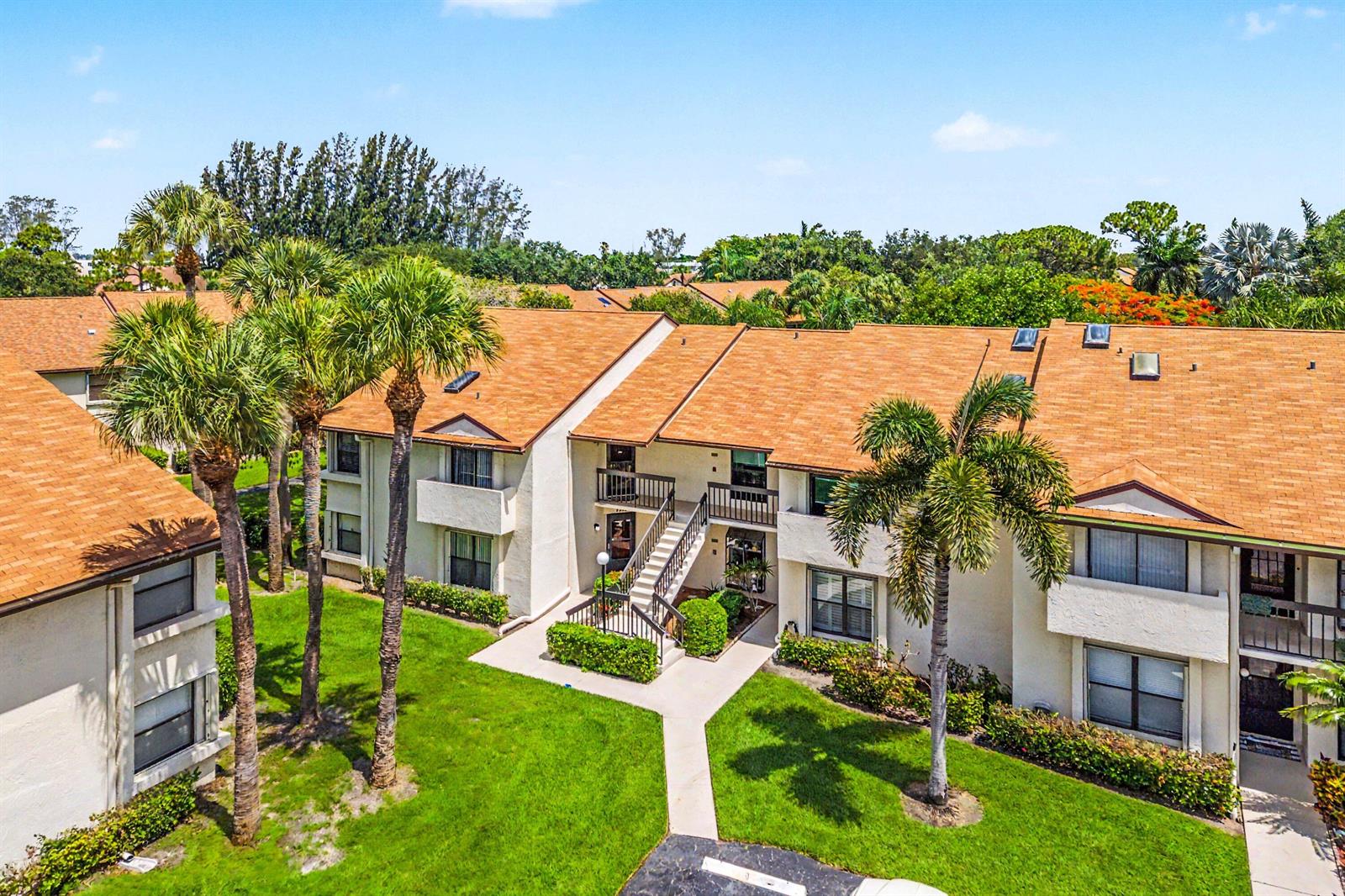 An exterior view of a two-story apartment building with palm trees and a grassy lawn — 3315 Lucerne Park Drive, FL 33467, FL