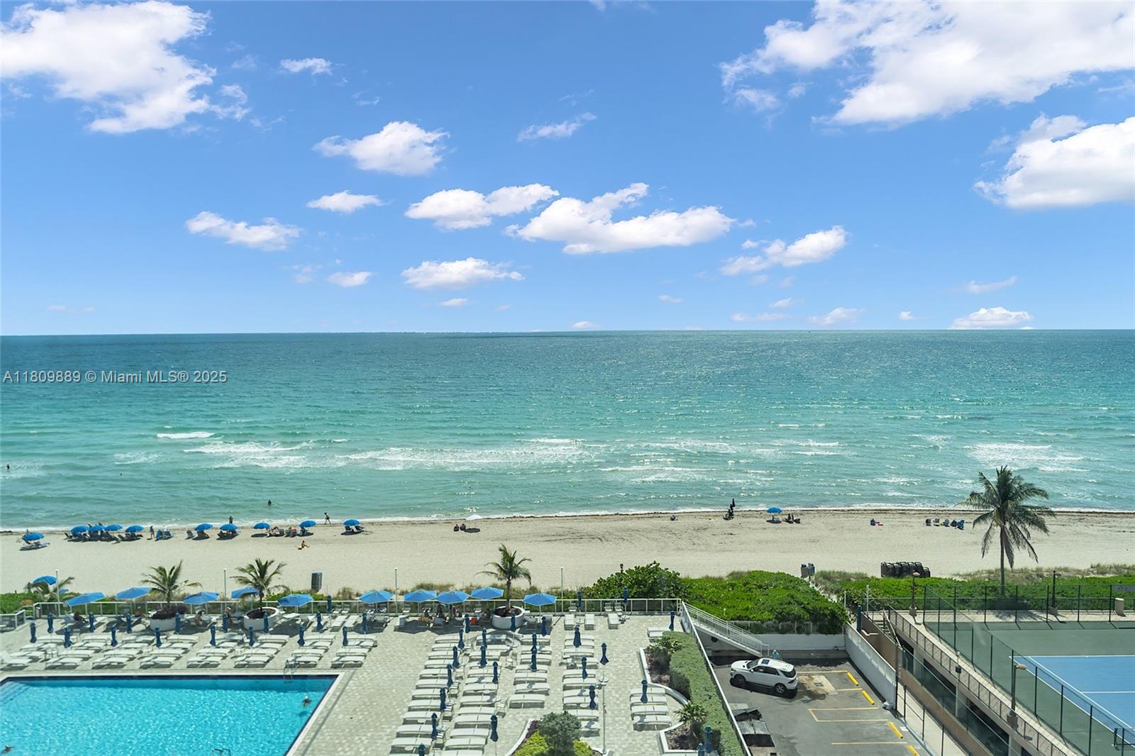 An elevated view shows a swimming pool, tennis court, and sandy beach along the ocean — 1904 S Ocean Dr # 1004, Hallandale Beach FL 33009, HALLANDALE BEACH, FL