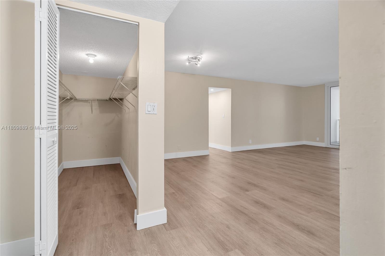 An interior view shows a room with light-colored walls, wood-look flooring, and an open closet — 1904 S Ocean Dr # 1004, Hallandale Beach FL 33009, HALLANDALE BEACH, FL