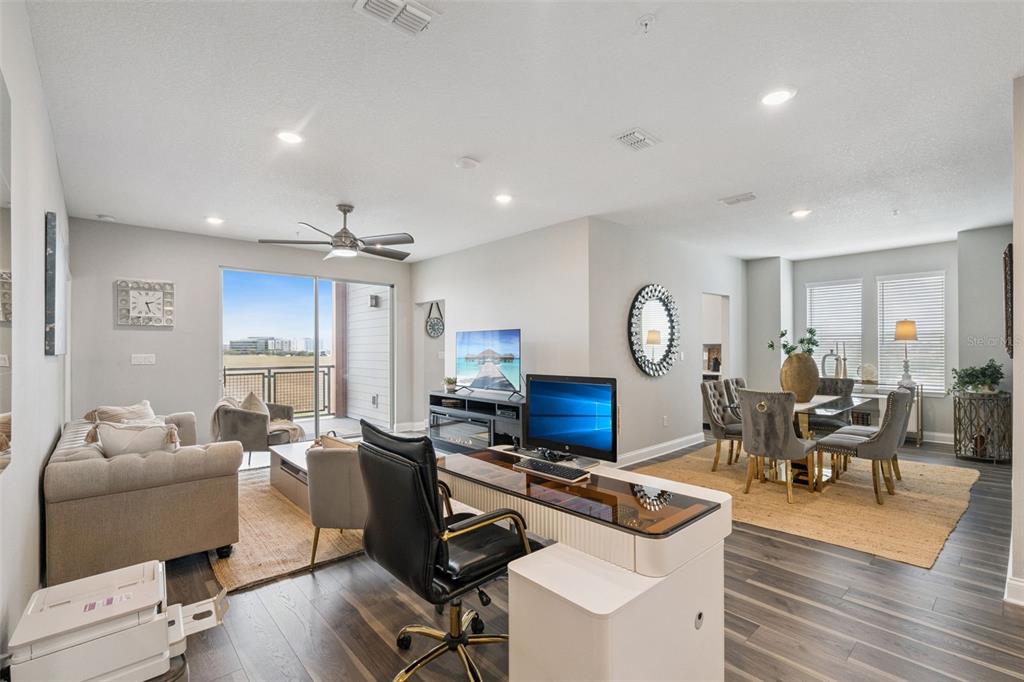 A living room features a sofa, two armchairs, a coffee table, and a sliding glass door — 7521 LAUREATE BOULEVARD UNIT 5306, ORLANDO, FL