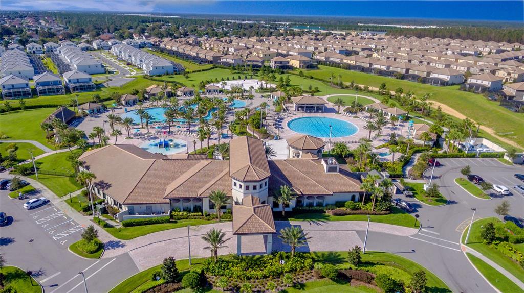 An aerial view shows a community clubhouse with swimming pools, parking lots, and surrounding houses — 8899 CABOT CLIFFS DRIVE UNIT 102, DAVENPORT, FL