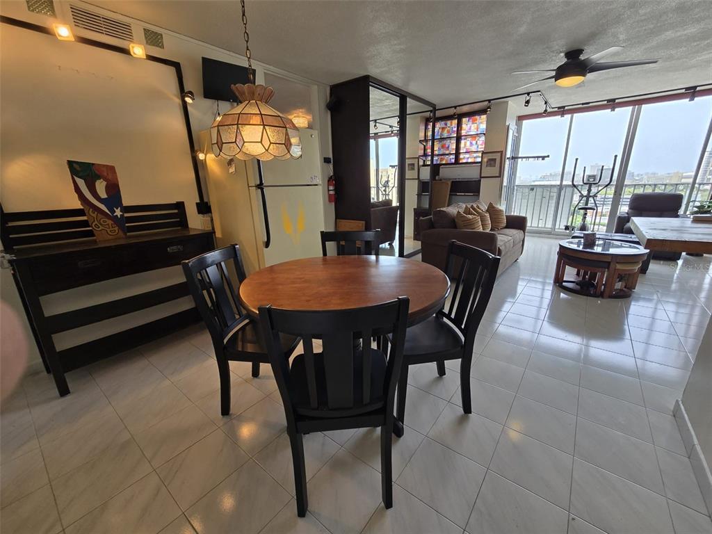 An outdoor courtyard features palm trees, seating areas, and buildings with decorative concrete screen walls — 500 AVE. LUIS MUÑOZ RIVERA UNIT 1003, SAN JUAN, PR