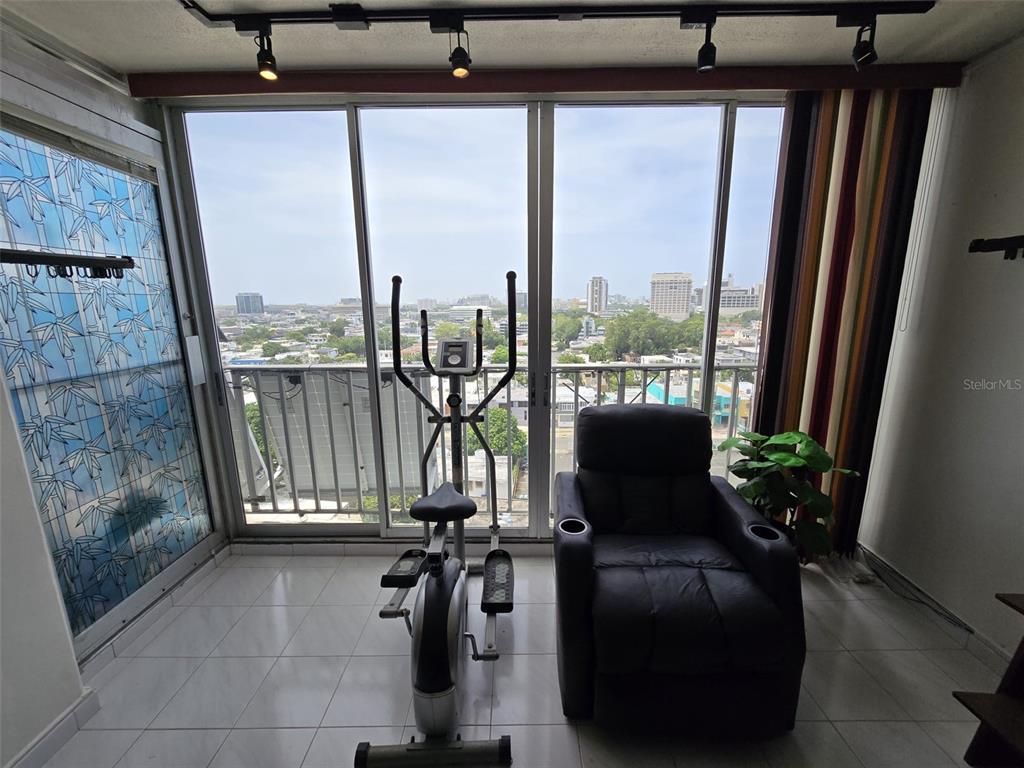 A dining area with a round wooden table and chairs sits before a living room — 500 AVE. LUIS MUÑOZ RIVERA UNIT 1003, SAN JUAN, PR