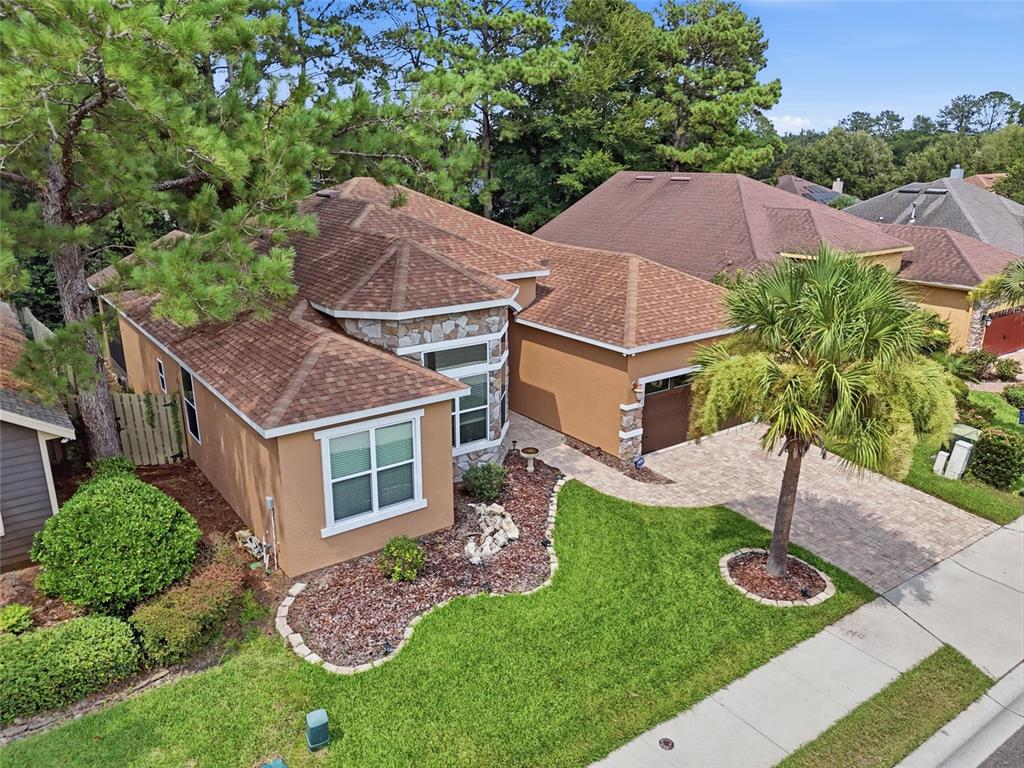 An aerial view of a tan, single-story house with a stone facade and shingled roof — 14504 NW 25TH AVENUE, NEWBERRY, FL