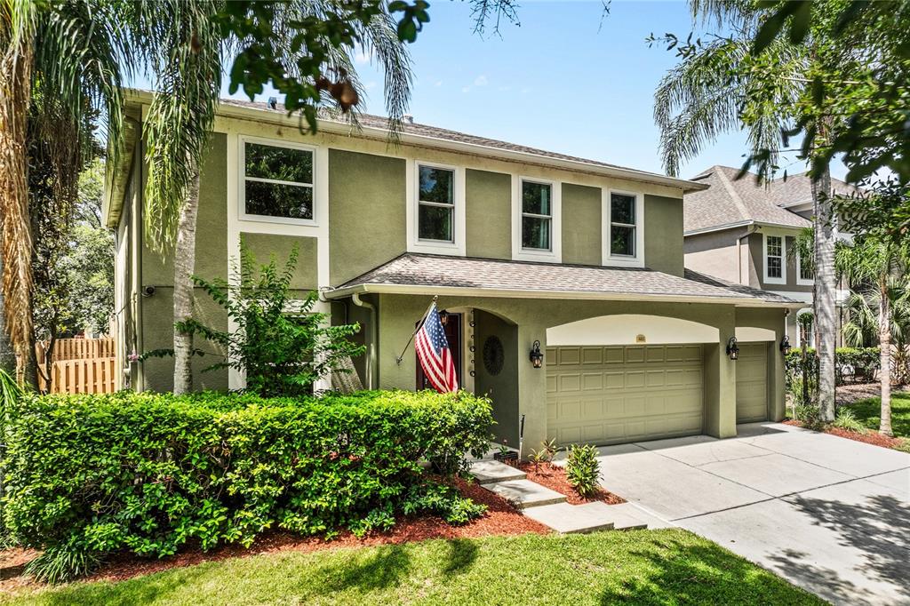 A two-story house with olive green stucco siding, a three-car garage, and a front hedge — 483 VIA TUSCANY LOOP, LAKE MARY, FL