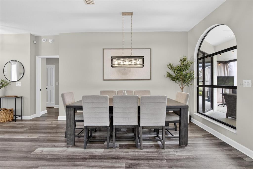 A dining room features a rectangular table, six upholstered chairs, a pendant light, and flooring — 11203 LONGBROOKE DRIVE, RIVERVIEW, FL
