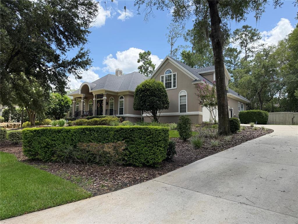 A kitchen features white cabinetry, a stainless steel gas range, and a patterned tile backsplash — 8613 SW 39TH LANE, GAINESVILLE, FL