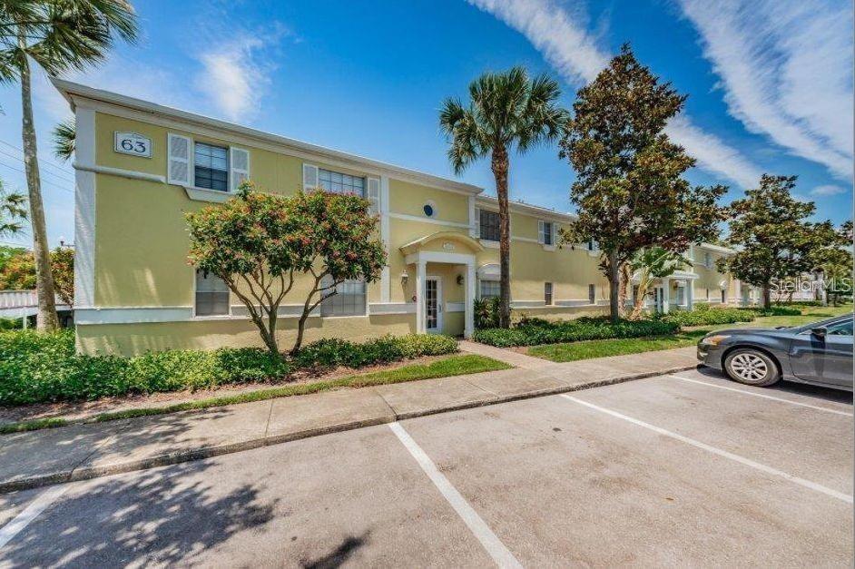 A two-story yellow apartment building with a parking lot in the foreground — 3889 POMPANO DRIVE SE UNIT C, ST PETERSBURG, FL