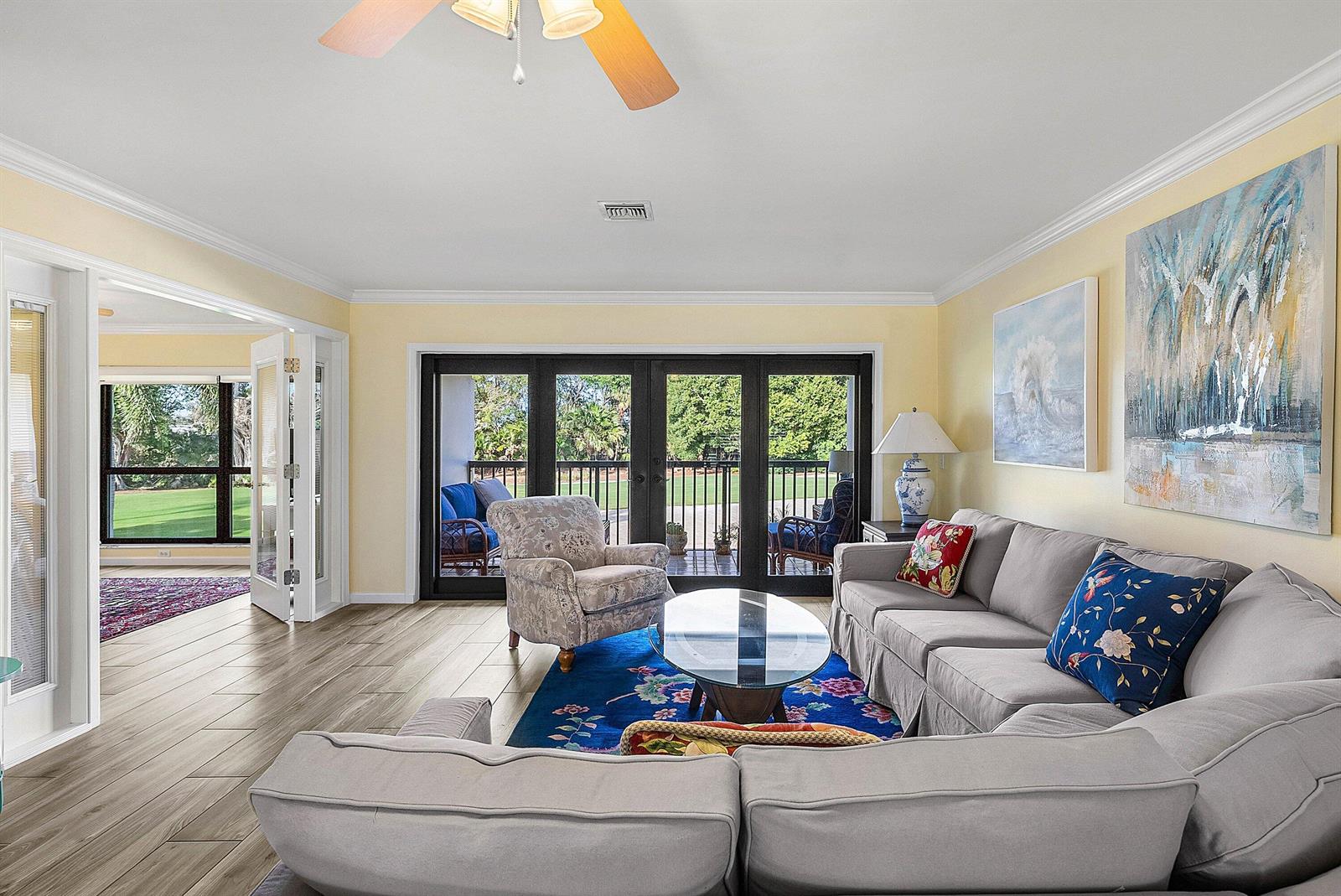 A living room features light yellow walls, a grey sectional, and glass doors to a balcony — 11272 Quail Covey Road, Boynton Beach FL 33436, BOYNTON BEACH, FL