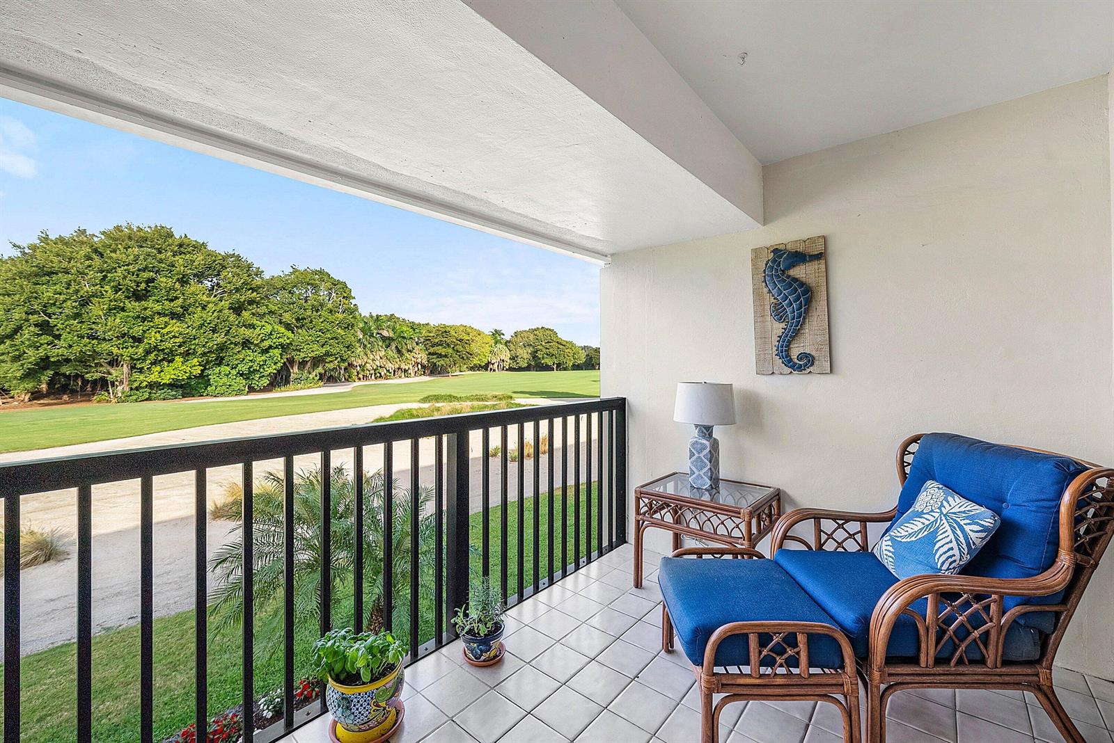 A balcony with tile flooring, wicker furniture, and a view of a golf course — 11272 Quail Covey Road, Boynton Beach FL 33436, BOYNTON BEACH, FL