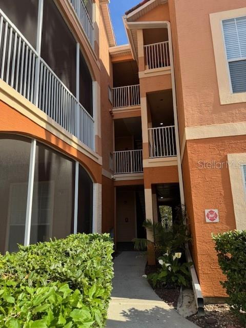 An exterior view of a multi-story apartment building with screened balconies and a central walkway — 5000 CULBREATH KEY WAY UNIT 1-219, TAMPA, FL
