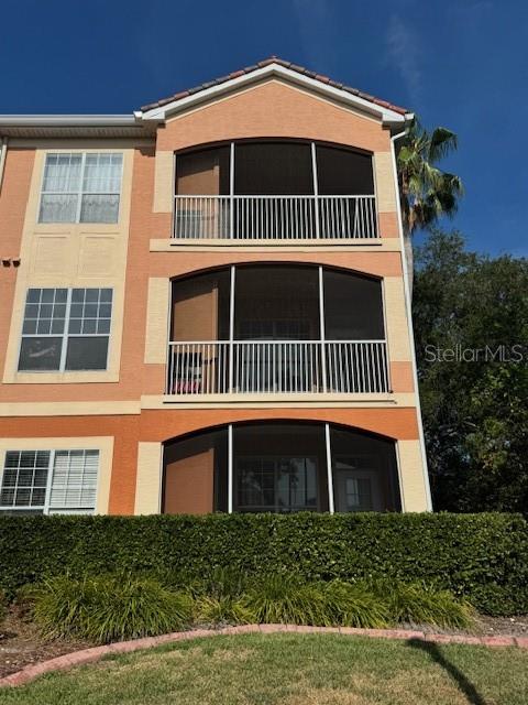The exterior of a three-story peach-colored apartment building features screened balconies and white railings — 5000 CULBREATH KEY WAY UNIT 1-219, TAMPA, FL
