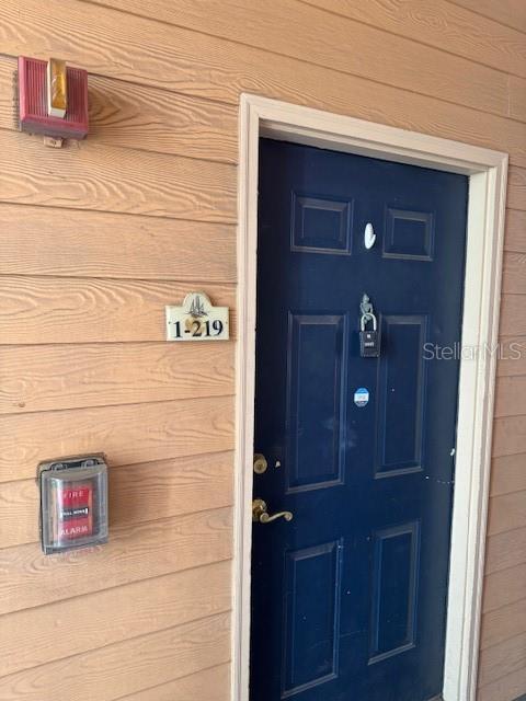 A dark blue apartment door with a lockbox and a fire alarm on the wall — 5000 CULBREATH KEY WAY UNIT 1-219, TAMPA, FL