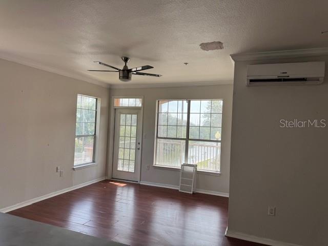 A living room with wood-look flooring, a ceiling fan, and a wall-mounted air conditioning unit — 5000 CULBREATH KEY WAY UNIT 1-219, TAMPA, FL