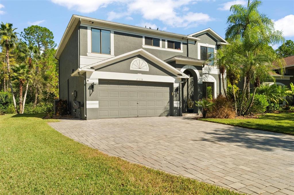 A two-story house with a gray exterior, a paved driveway, and a two-car garage — 13228 ROYAL GEORGE AVENUE, ODESSA, FL