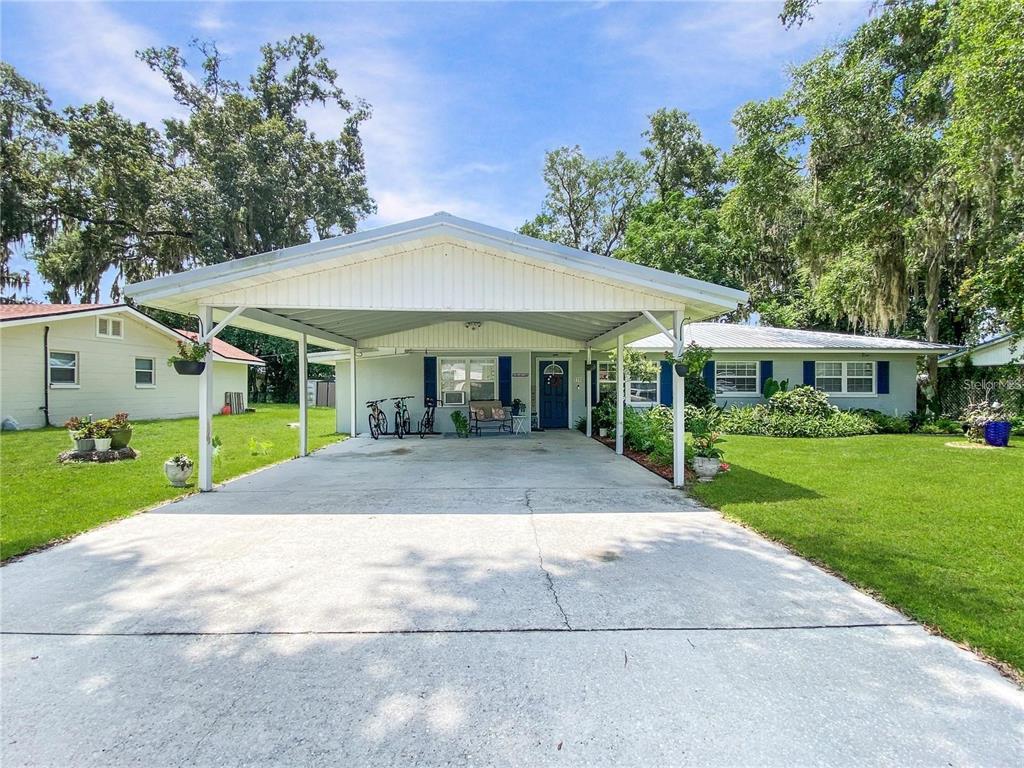A single-story house with a large white carport and a concrete driveway — 228 SE OAK HILL STREET, LAKE CITY, FL