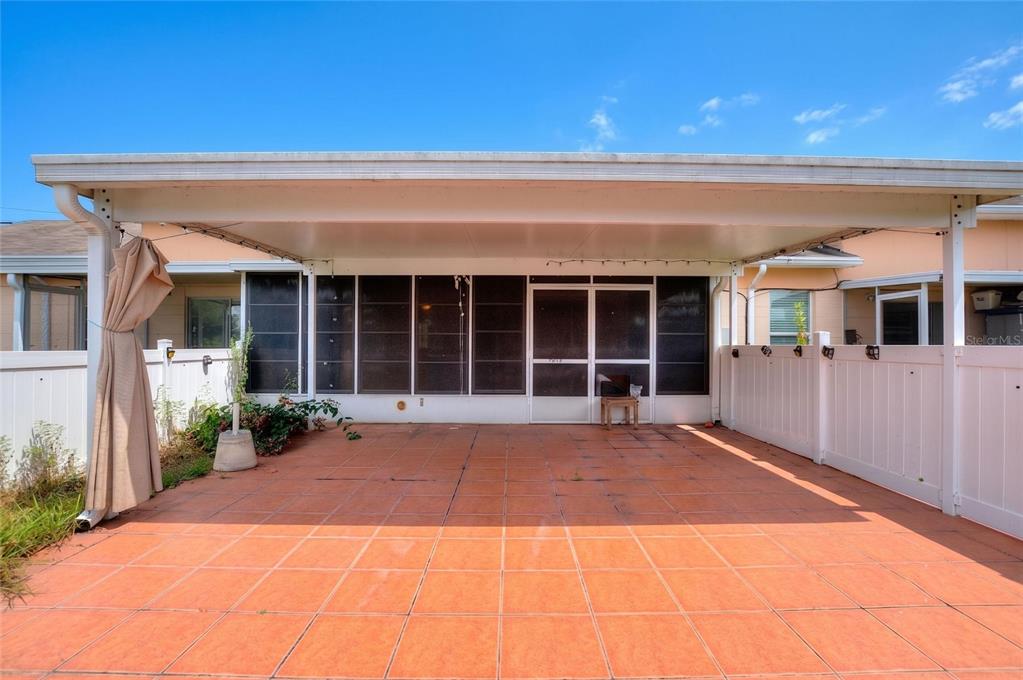 A covered patio with orange tile flooring and a screened-in enclosure — 2637 CLUB CIRCLE, LAKE WALES, FL