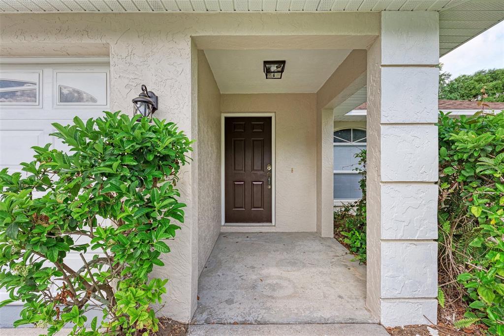 A living room with light-colored walls, wood-look flooring, a ceiling fan, and an arched window — 2046 OLD TREVOR WAY, SARASOTA, FL