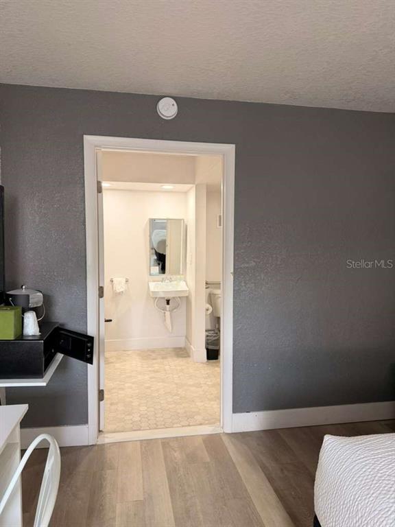 A view from a bedroom into a bathroom with a wall-mounted sink and tiled floor — 5367 W IRLO BRONSON MEMORIAL HIGHWAY UNIT 3-108, KISSIMMEE, FL