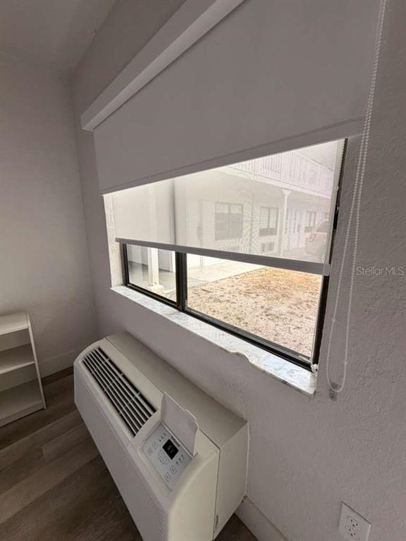 A room features a window with a roller shade, a wall-mounted air conditioner, and flooring — 5367 W IRLO BRONSON MEMORIAL HIGHWAY UNIT 3-108, KISSIMMEE, FL