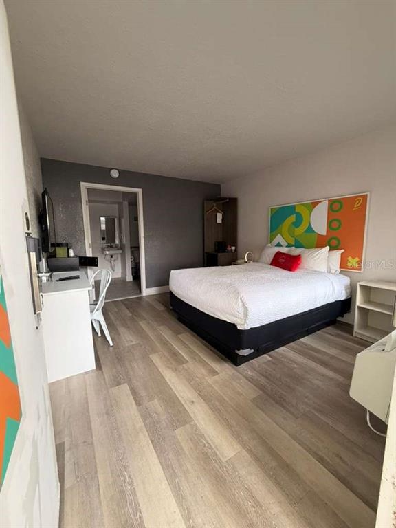 A hotel room features a bed, a desk, a small open closet, and wood-look flooring — 5367 W IRLO BRONSON MEMORIAL HIGHWAY UNIT 3-108, KISSIMMEE, FL