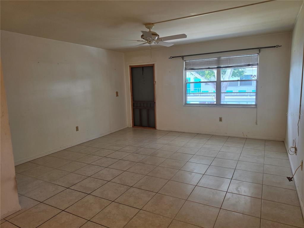 An empty room with beige tile flooring, a ceiling fan, and a window with blinds — 5850 21ST STREET N UNIT 15, ST PETERSBURG, FL