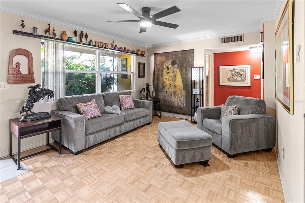 A living room features gray furniture, a ceiling fan, and parquet flooring — 2042 ISABELLE STREET, LARGO, FL