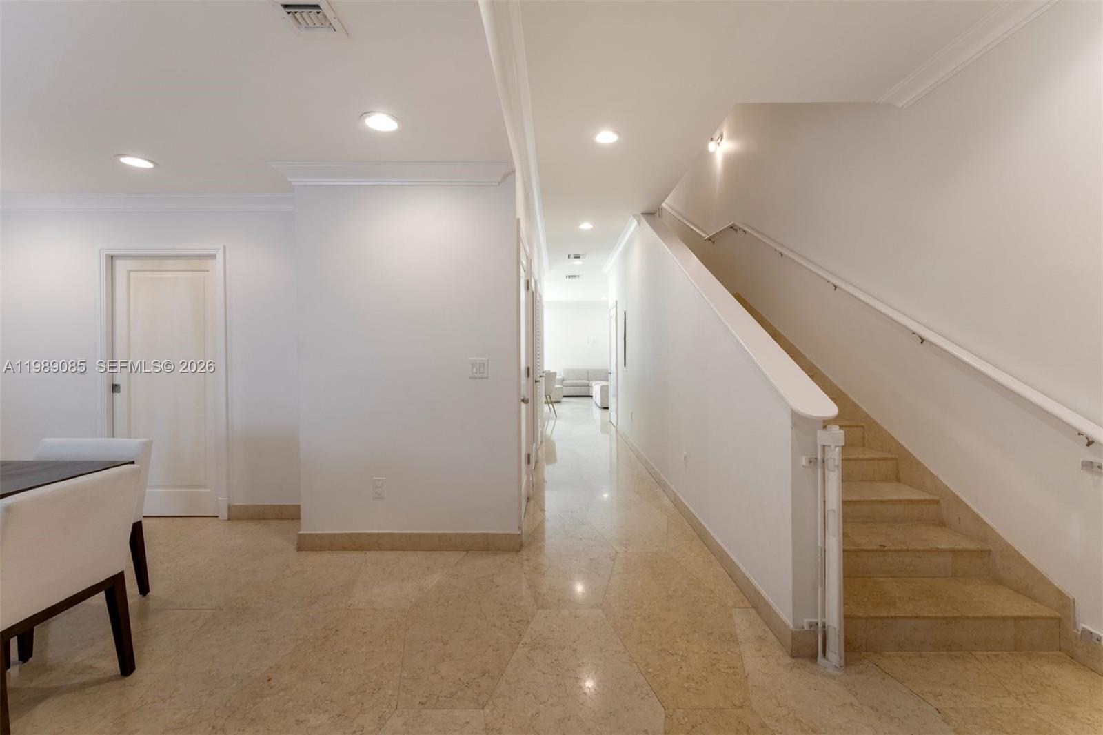 A hallway with light tile flooring leads past a staircase to a distant room — 1566 NE Quayside Ter # D14, Miami FL 33138, MIAMI, FL