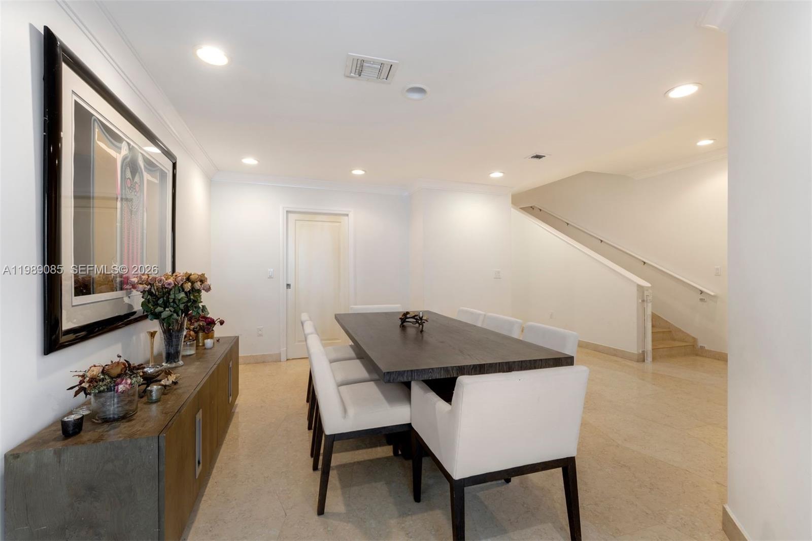 A dining room features a dark wood table, white chairs, and a matching sideboard — 1566 NE Quayside Ter # D14, Miami FL 33138, MIAMI, FL