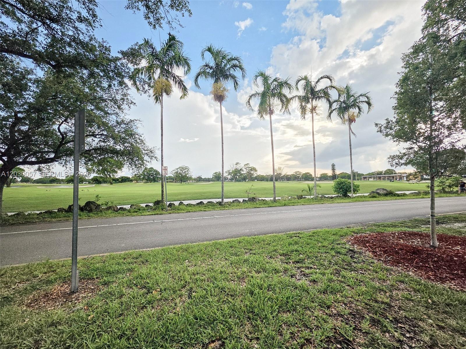A paved road runs in front of a grassy golf course lined with palm trees — 6235 Kendale Lakes Cir # 236, Miami FL 33183, MIAMI, FL