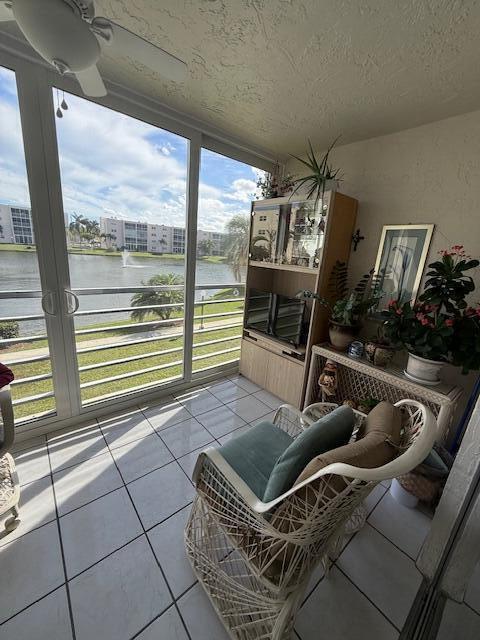 A sunroom with tile floors, wicker furniture, and a view of a lake and buildings — 324 SE 10th Street # 207, Dania Beach FL 33004, DANIA BEACH, FL