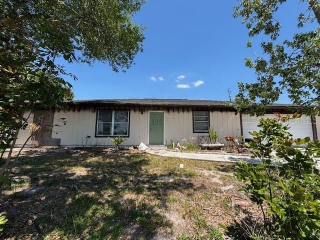 A single-story house with light-colored siding, a green front door, and a dark shingled roof — 3538 PINETREE STREET, PORT CHARLOTTE, FL