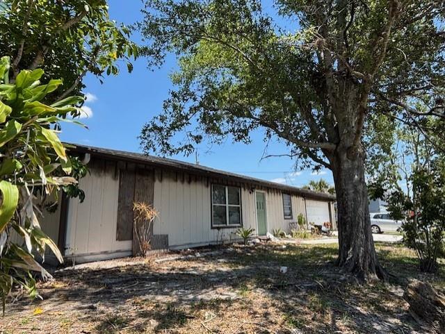 A single-story house with light-colored siding and a large tree in the front yard — 3538 PINETREE STREET, PORT CHARLOTTE, FL