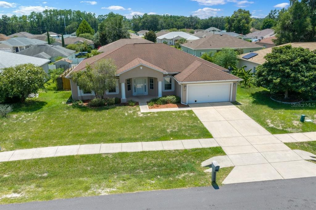 An aerial view of a single-story house with a brown roof and a concrete driveway — 3024 NE 27TH STREET, OCALA, FL