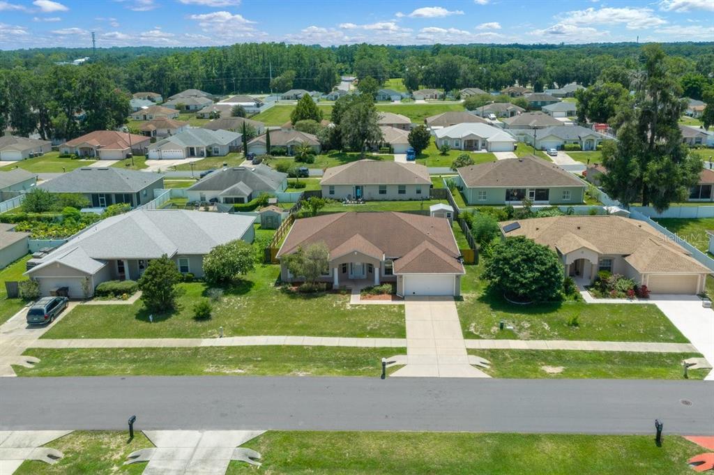 An aerial view shows a suburban neighborhood with single-family homes and manicured lawns — 3024 NE 27TH STREET, OCALA, FL